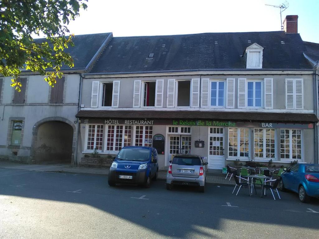 un edificio con coches estacionados frente a él en Le Relais De La Marche, en Aigurande