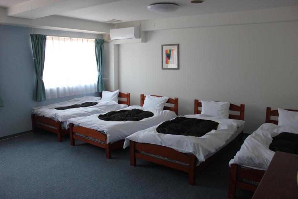 Postel nebo postele na pokoji v ubytování Grampus Inn Shirahama