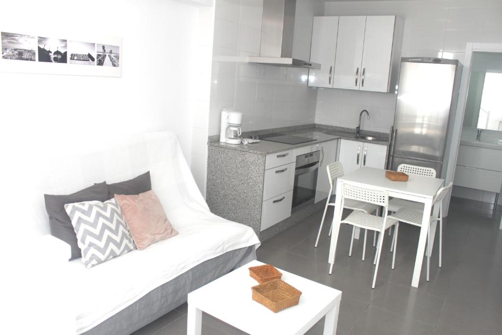 ein Wohnzimmer mit einem weißen Sofa und einer Küche in der Unterkunft Apartamento Gaviotas in Tarifa