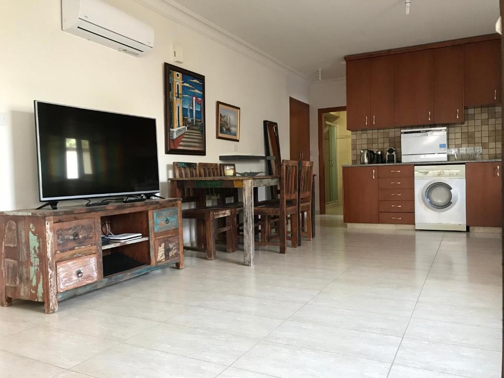 a living room with a flat screen tv on a wooden entertainment center at Mystra Place in Nicosia