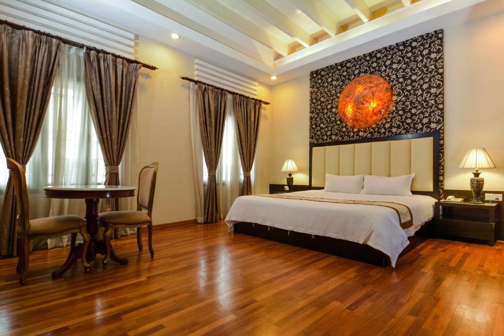 a bedroom with a bed and a desk and a table at Jonker Boutique Hotel in Malacca