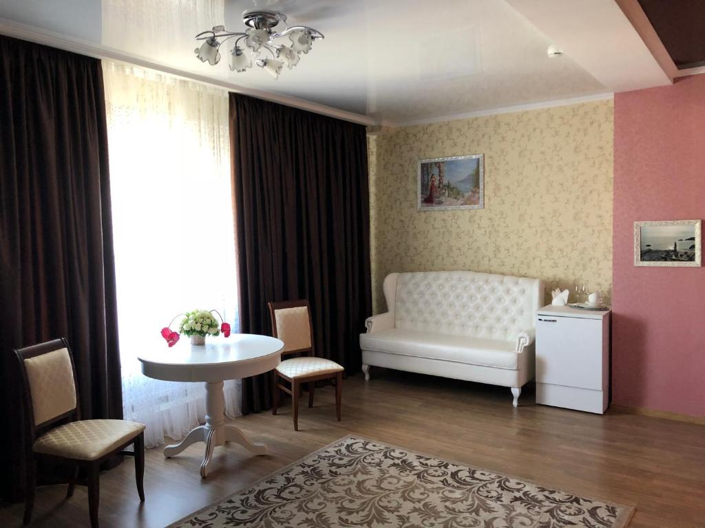 a living room with a white couch and a table at Ritsa Hall in Krasnodar