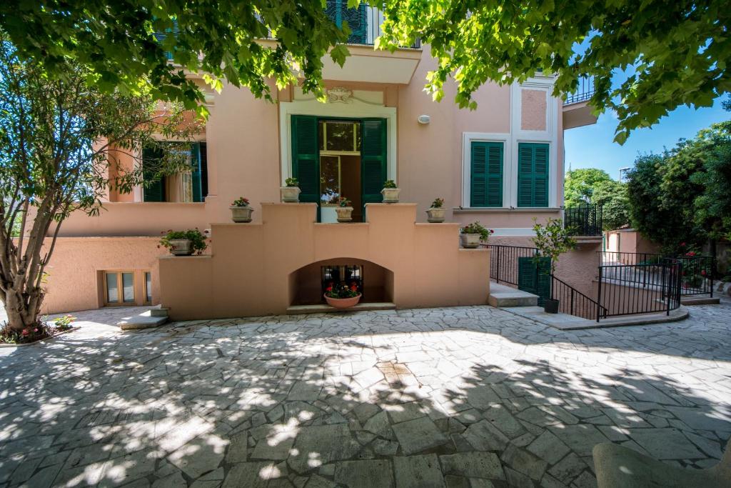 a house with a stone patio in front of it at Ostello San Luigi Orione in Anzio