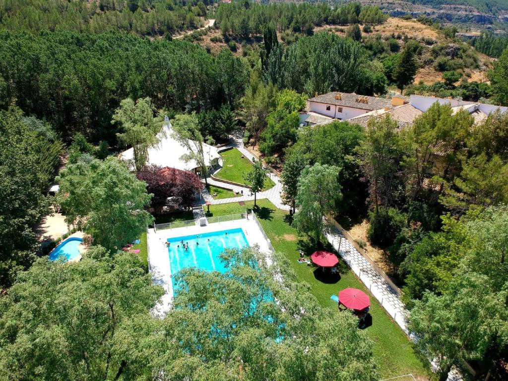 an overhead view of a swimming pool with umbrellas at Hotel Resort Cueva del Fraile in Cuenca