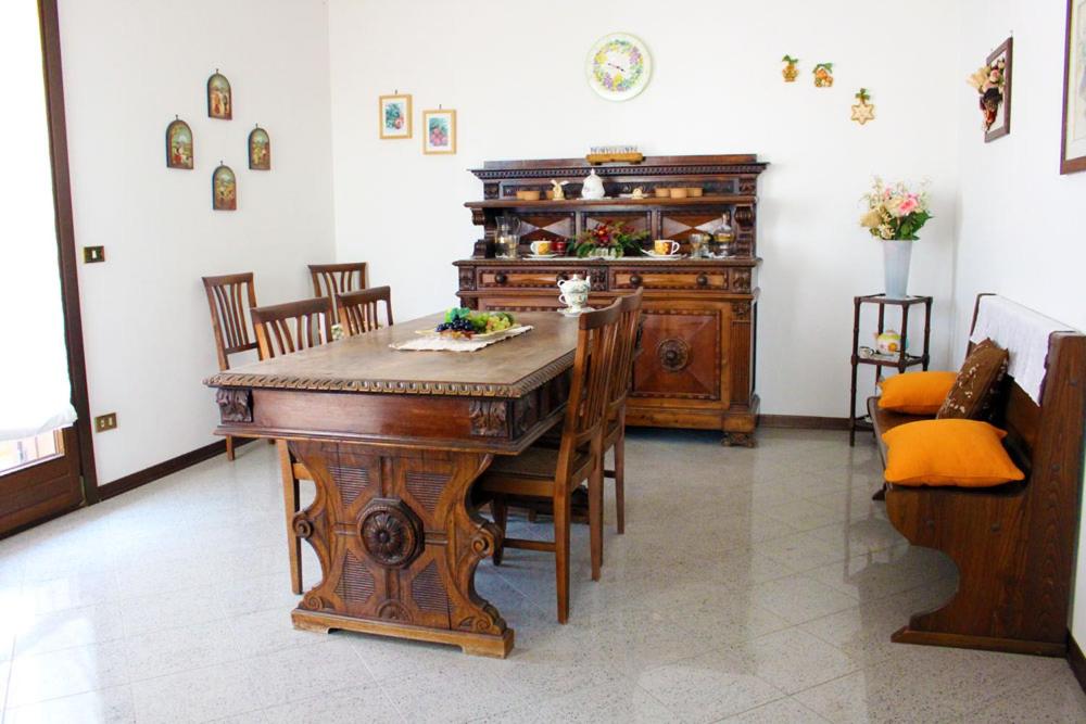 uma sala de jantar com uma mesa de madeira e cadeiras em Appartamento Belvedere em Manciano