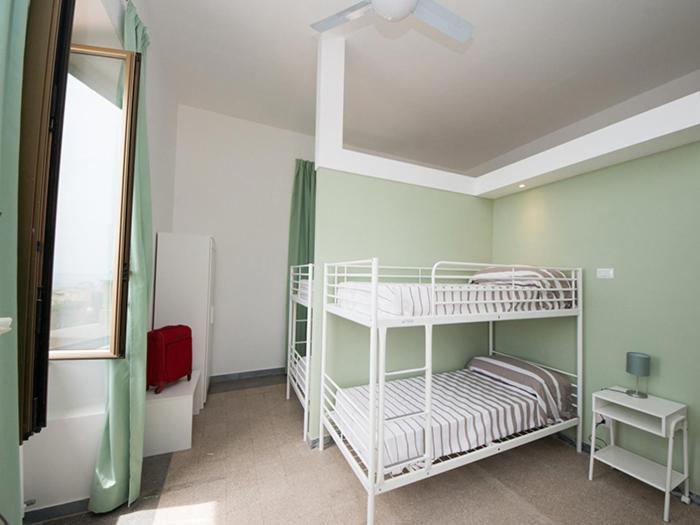 a room with two bunk beds and a window at Ostello San Luigi Orione in Anzio
