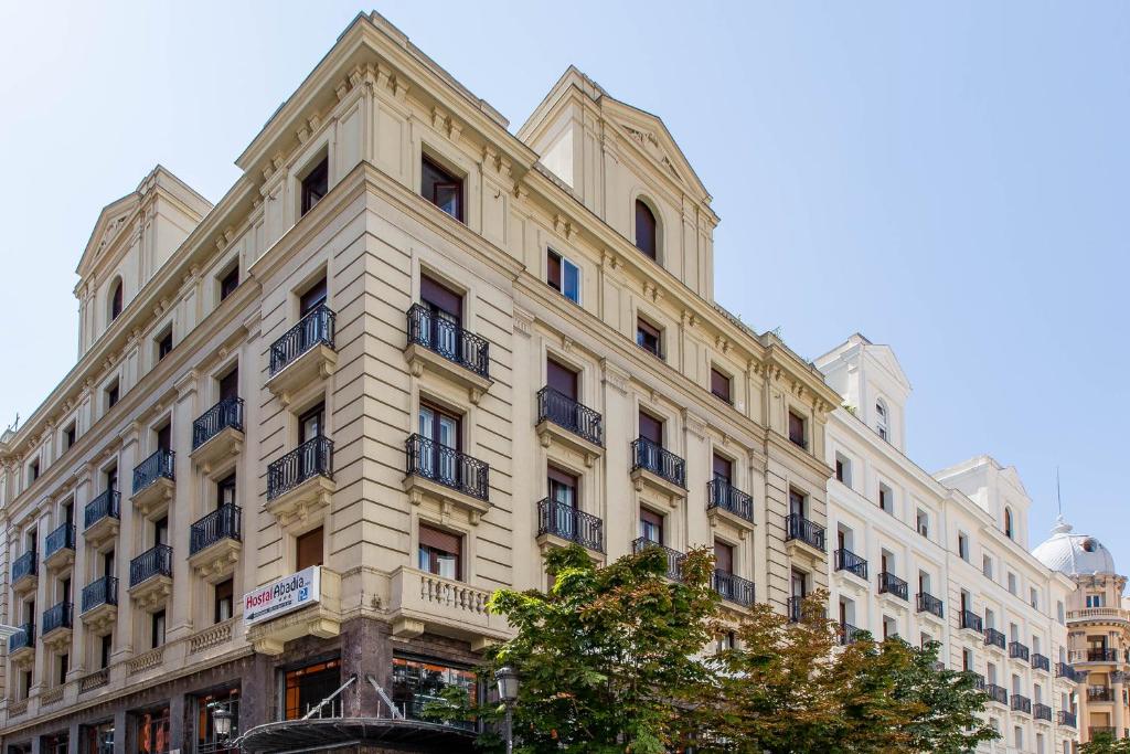 a large white building on a city street at Hostal Abadia Madrid in Madrid