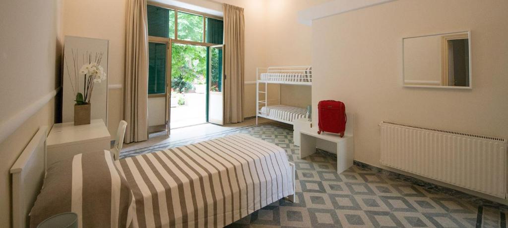 a room with a bedroom with a bed and a chair at Ostello San Luigi Orione in Anzio