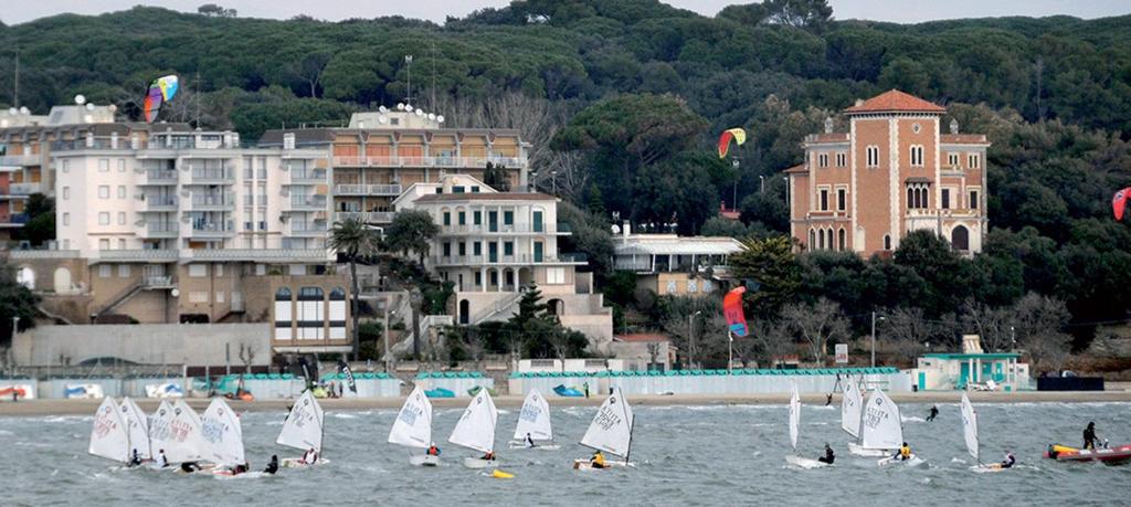 a group of sailboats in the water near a city at Ostello San Luigi Orione in Anzio