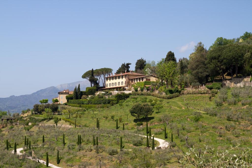 una casa en la cima de una colina con árboles en Relais Farinati - Adults only, en Lucca