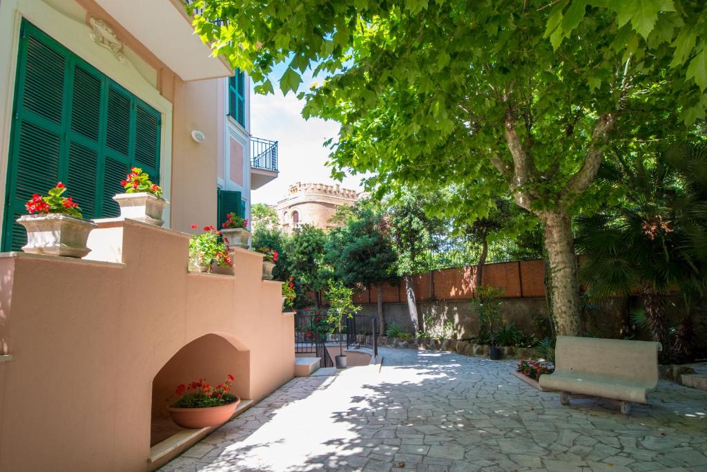 a courtyard of a house with a tree and a bench at Ostello San Luigi Orione in Anzio
