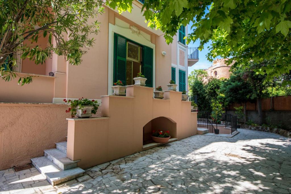 a house with stairs and a window with potted plants at Ostello San Luigi Orione in Anzio
