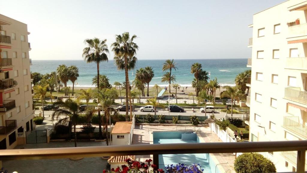 アルムニェーカルにあるApartamento Amapolaのホテルのバルコニーからビーチの景色を望めます。