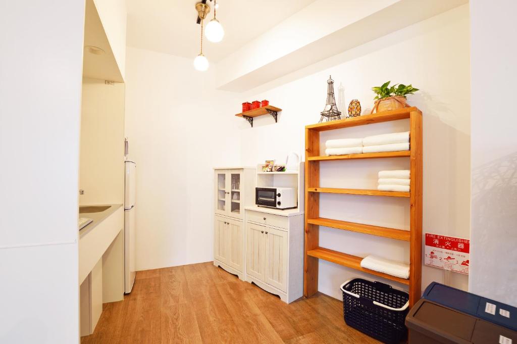 una cucina con pareti bianche e mensola in legno di Douce a Ginowan