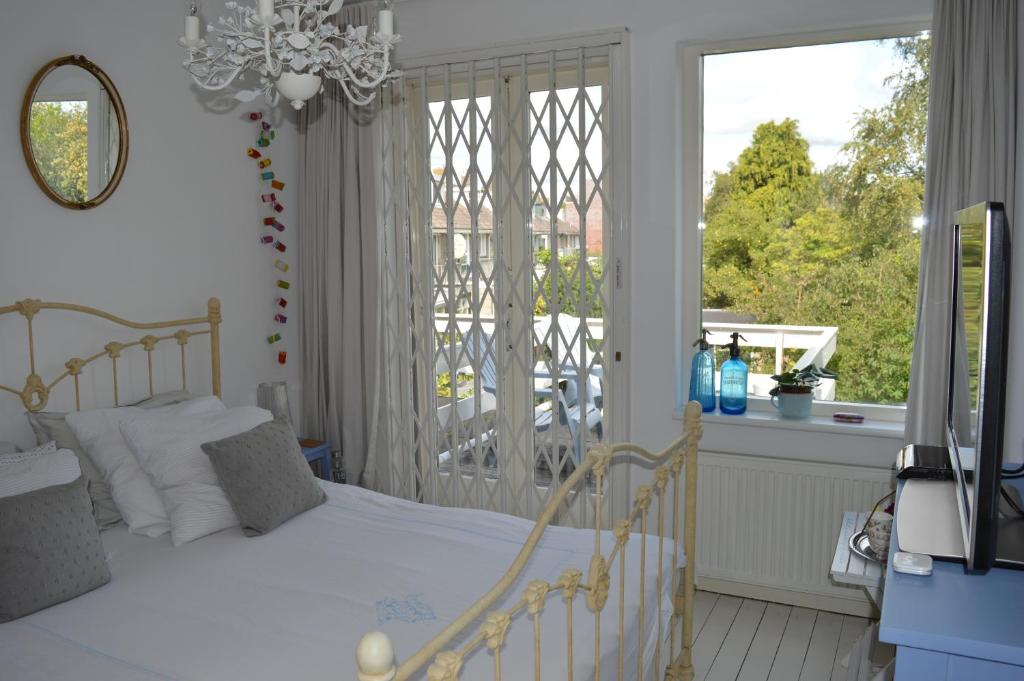 sypialnia z białym łóżkiem i oknem w obiekcie Bed & Breakfast Jo Amsterdam w Amsterdamie