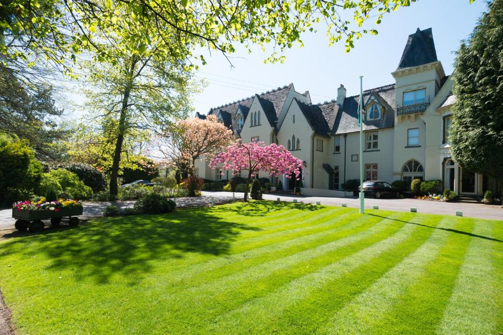 een huis met een gazon ervoor bij Glen-Yr-Afon House Hotel in Usk