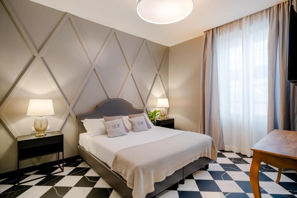 ローマにあるデセオ ホームのチェッカーボードフロアのベッドルーム1室(大型ベッド1台付)