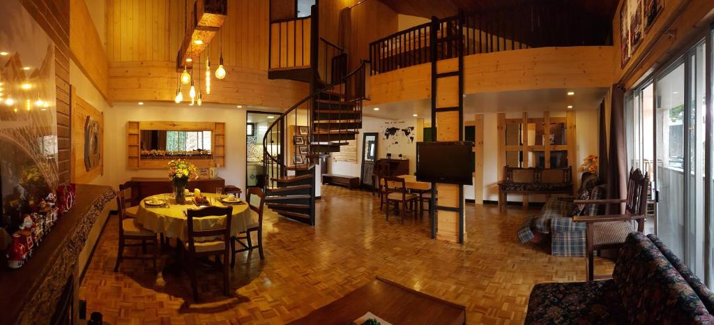 uma grande sala de estar com uma mesa e cadeiras em HOMESTAY DE MARQS - STYLISH and SPACIOUS 3 BEDROOM VACATION HOME em Baguio