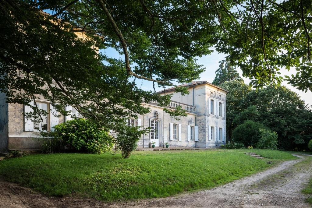 une vieille maison avec une cour herbeuse devant elle dans l'établissement Château Le Méjean, à Pessac-sur-Dordogne
