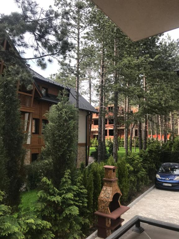 a view of a house with a car parked in a yard at Lux Apartman Daria in Zlatibor