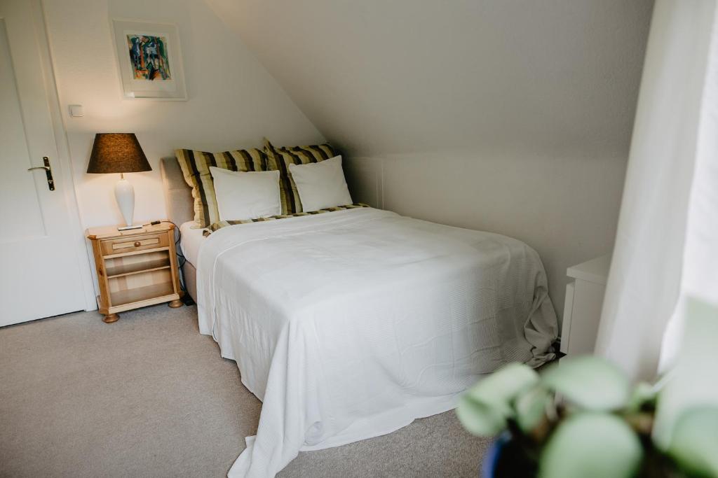 a bedroom with a bed and a night stand with a lamp at Bauernhaus in der Bremer Schweiz in Ritterhude