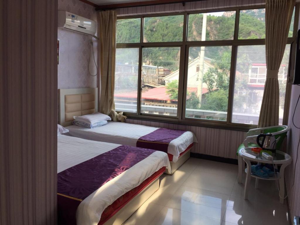 Postel nebo postele na pokoji v ubytování Tianjin Huangyaguan Great Wall Home Hotel