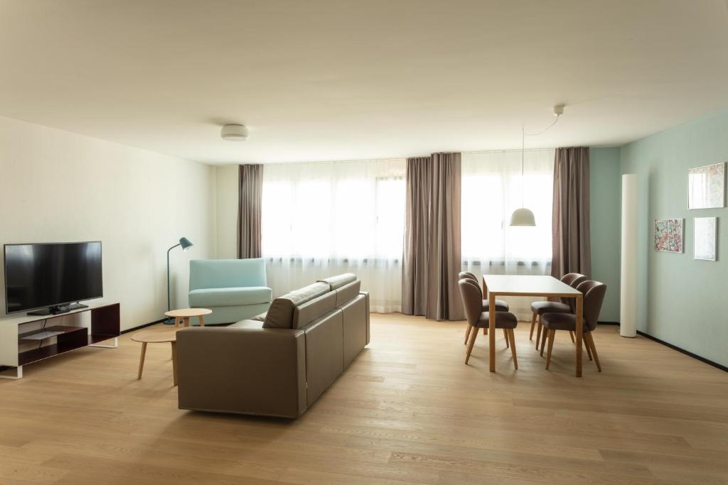 ein Wohnzimmer mit einem Sofa und einem Tisch in der Unterkunft EMA House Serviced Apartments Superior Downtown in Zürich