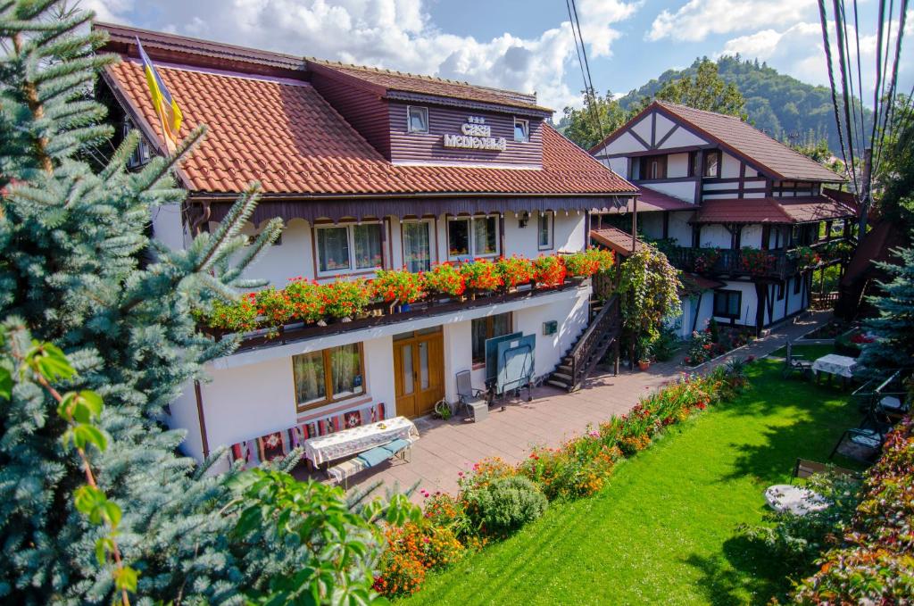 une maison avec des fleurs sur son côté dans l'établissement Pension Casa Medievala, à Bran