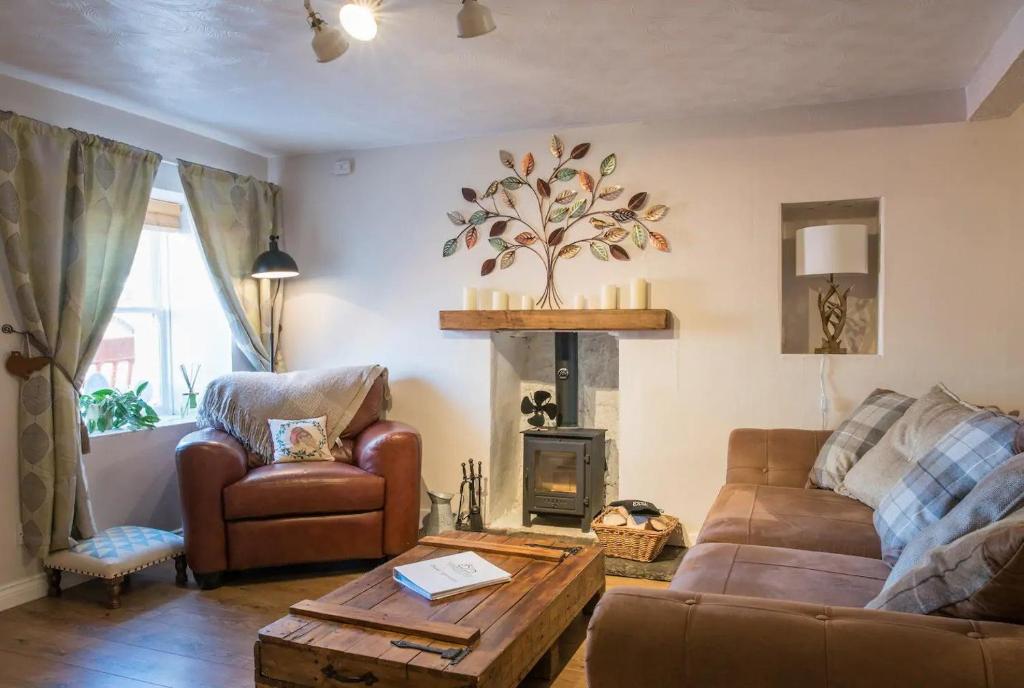 a living room with a couch and a fireplace at Country Nest in Carnwath