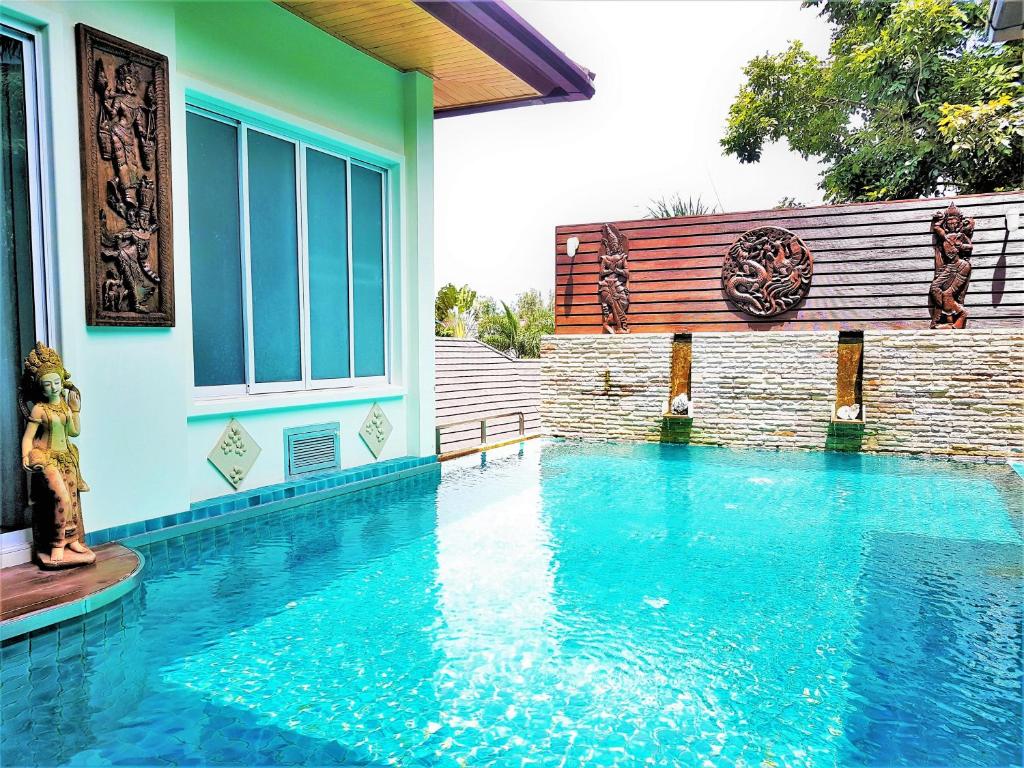 a swimming pool in front of a house at Prima Villas Karon Beach by PHR in Karon Beach
