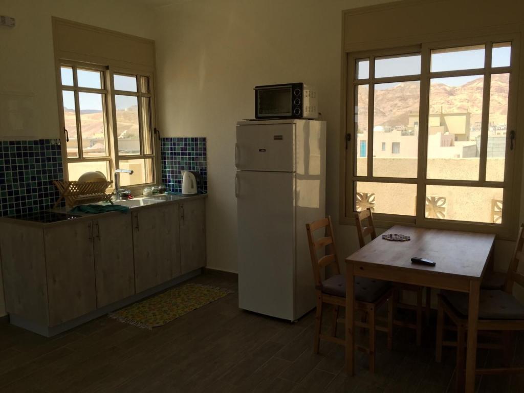 a kitchen with a refrigerator and a table with a microwave at The Birdwatchers Nest in Beʼer Ora