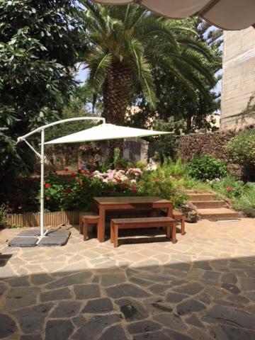 a picnic table and an umbrella in a garden at Casa Del Casco Historico in Las Lagunas