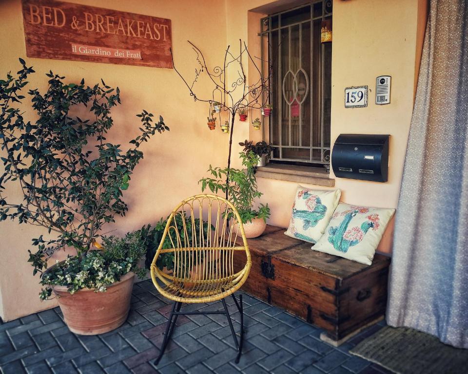 a patio with a bench and a window with plants at Il Giardino dei Frati in Roncofreddo