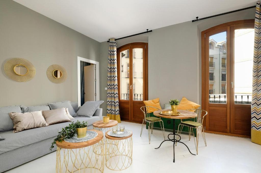een woonkamer met een bank en een tafel bij tuGuest San Gil Apartments in Granada