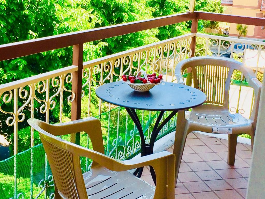 una mesa con 2 sillas y un bol de fruta en el balcón en Appartamento Andora mare, en Andora