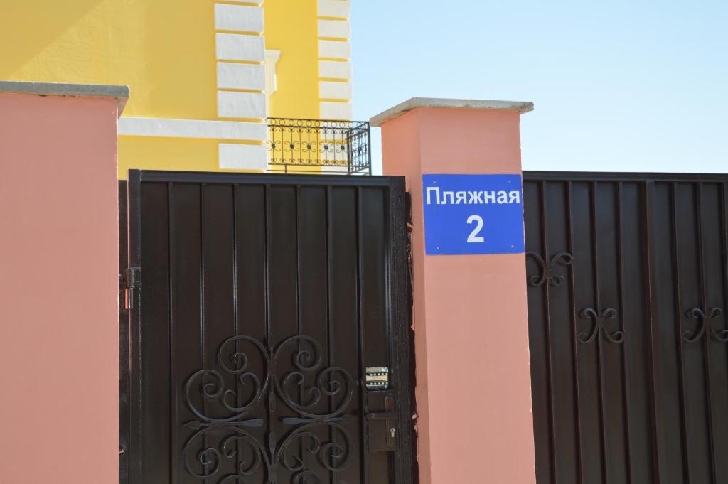 Czarna brama z niebieskim znakiem na budynku w obiekcie Apartments on Балауса, 2 w mieście Aktau