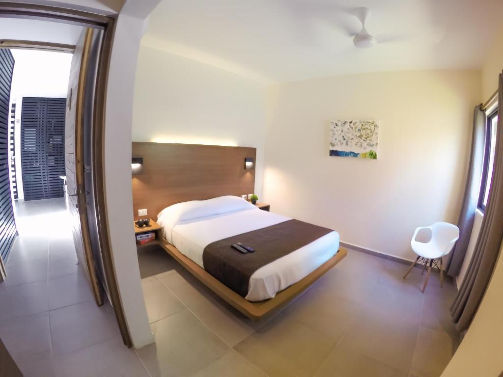 - une chambre avec un lit et une chaise dans l'établissement Viento Suites Cancún, à Cancún