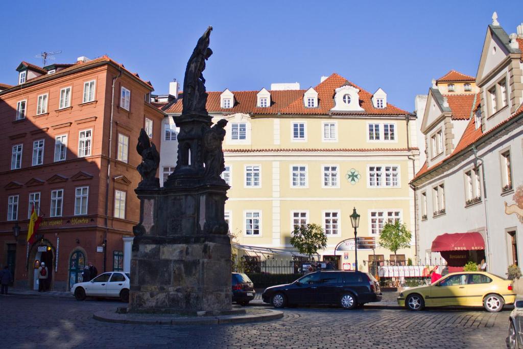 posąg na środku ulicy z budynkami w obiekcie Charles Bridge Suites w Pradze