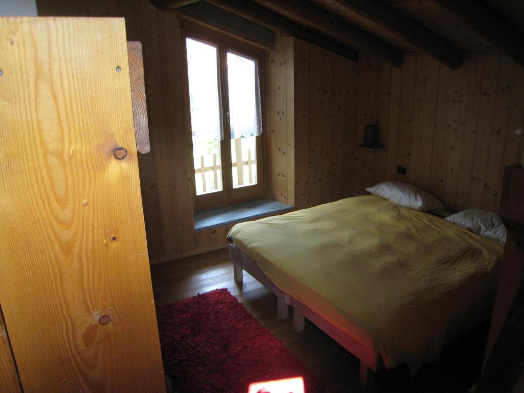 Schlafzimmer mit einem Bett und einem Fenster in der Unterkunft B&B da Sguincio in Piateda