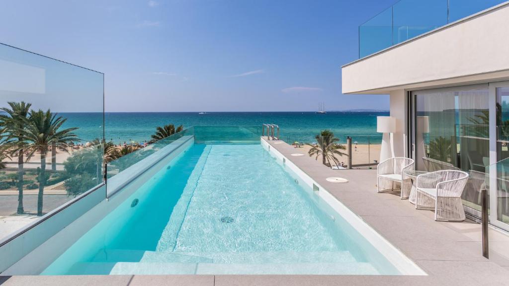 a swimming pool with the ocean in the background at The Hype Beachhouse in Playa de Palma