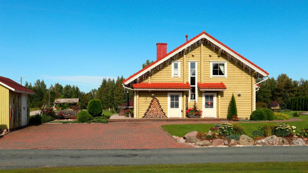 una casa amarilla con techo rojo en Veerpalu Villa, en Otepää