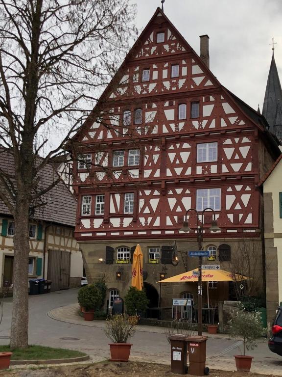 abered building with a large building at Altstadthotel Wilde Rose in Eppingen