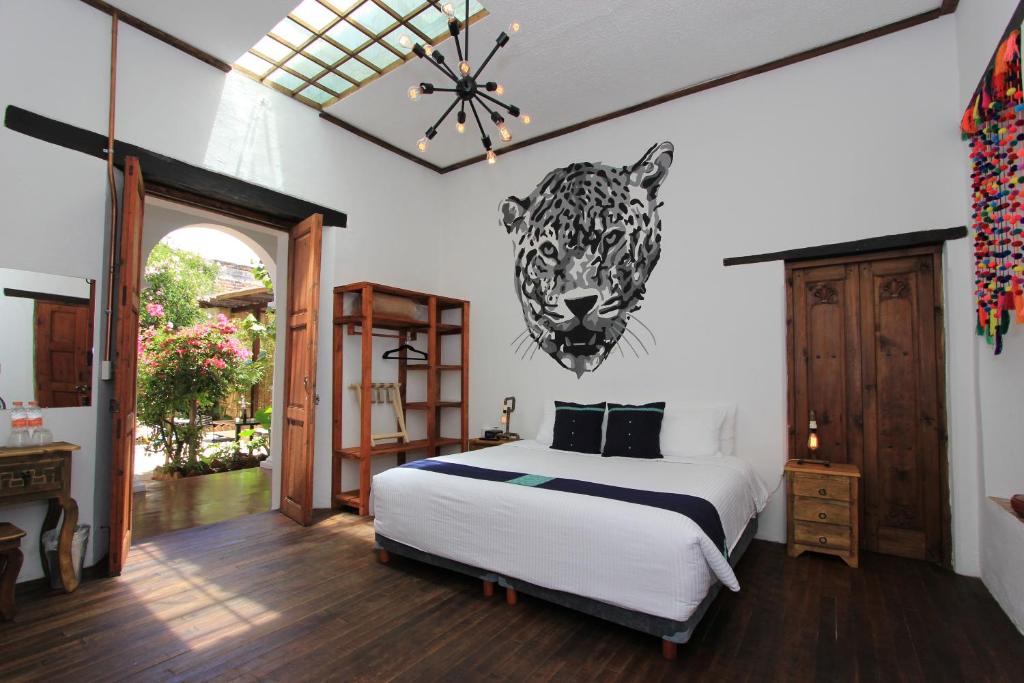 ein Schlafzimmer mit einem Bett mit einem Leopardenkopf an der Wand in der Unterkunft Sereno Art Hotel in San Cristóbal de las Casas
