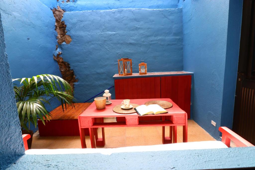 una mesa roja en una habitación con una pared azul en Barlovento 41 en Mocanal