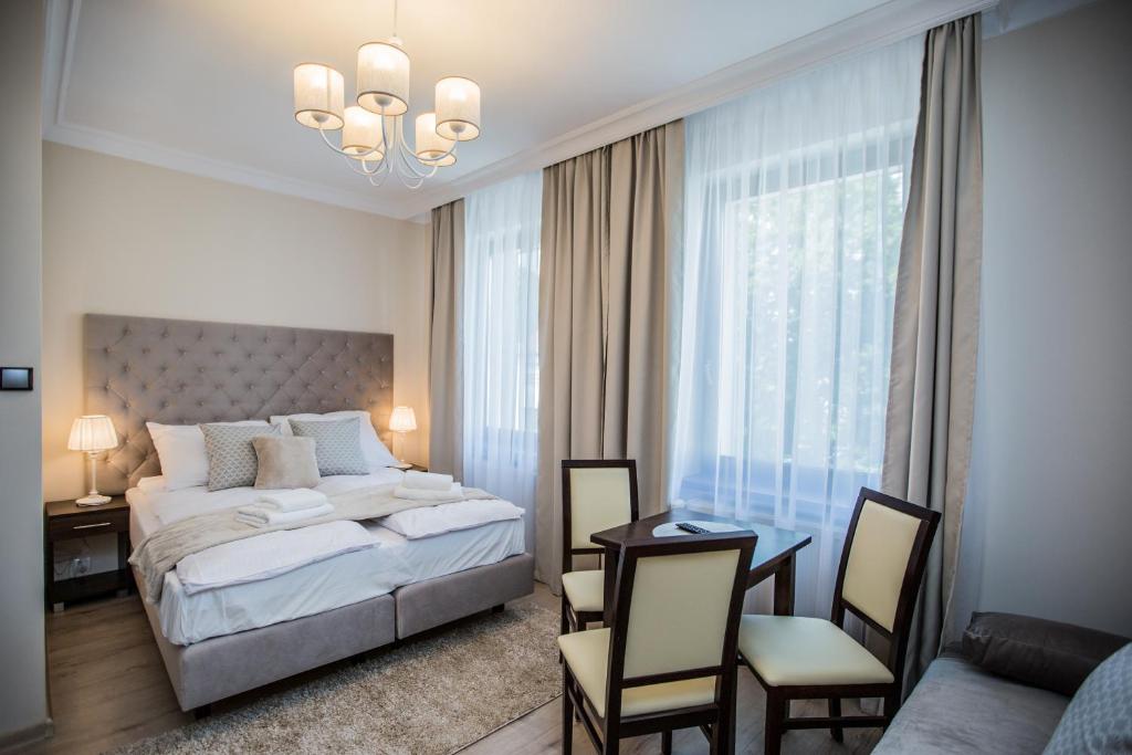 um quarto com uma cama, uma mesa e cadeiras em Villa Baltica em Świnoujście
