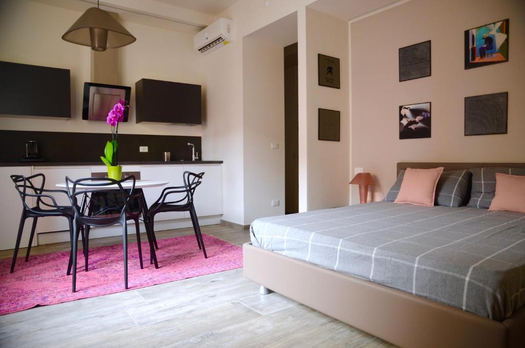 - une chambre avec un lit, une table et des chaises dans l'établissement My Home in Bologna - La Grassa, à Bologne