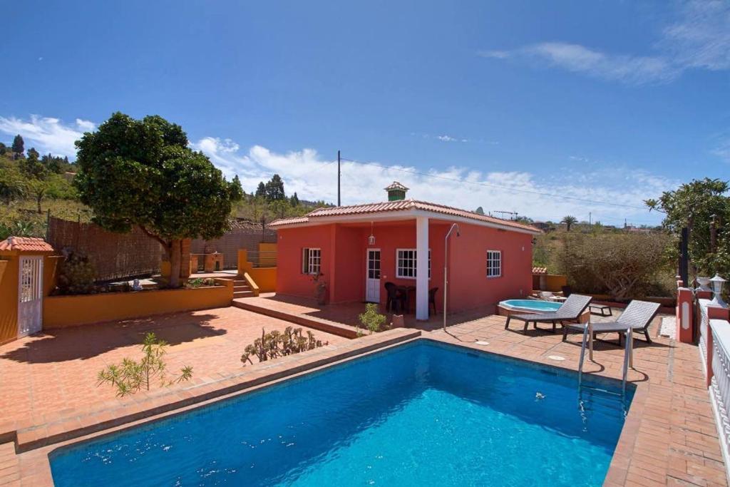 uma casa com piscina em frente a uma casa em Casa Cesar em Puntagorda