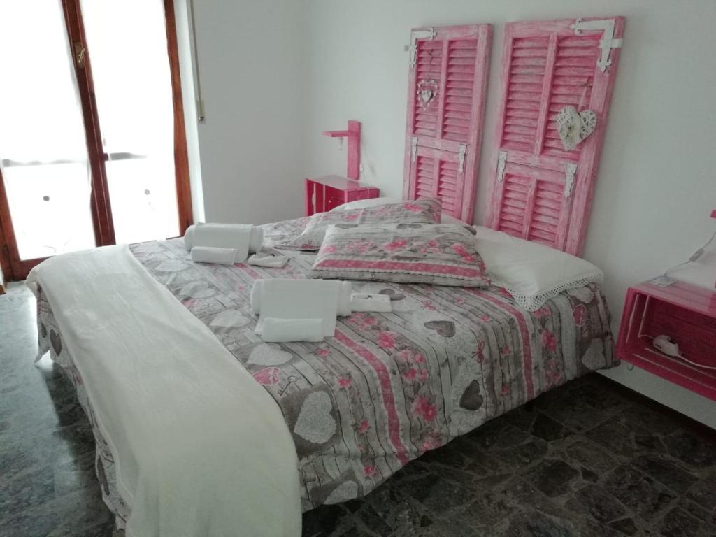 a bedroom with a bed with a pink headboard at Good Morning Shopping in Serravalle Scrivia