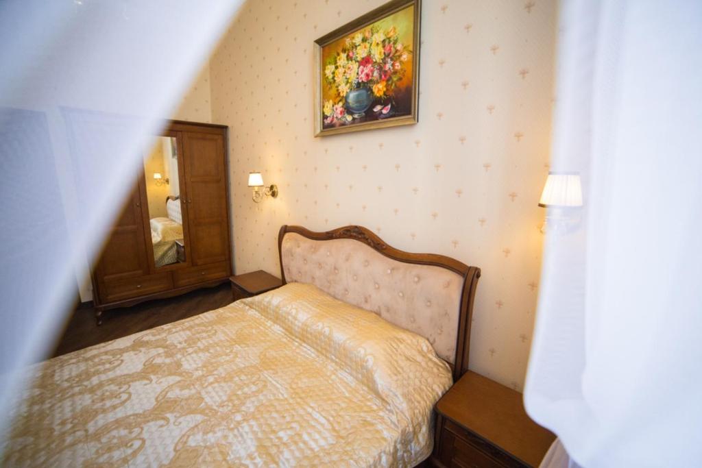 ein Schlafzimmer mit einem Bett und einem Wandgemälde in der Unterkunft V.I.P.Apartmens Rynok Sqr.19 in Lwiw