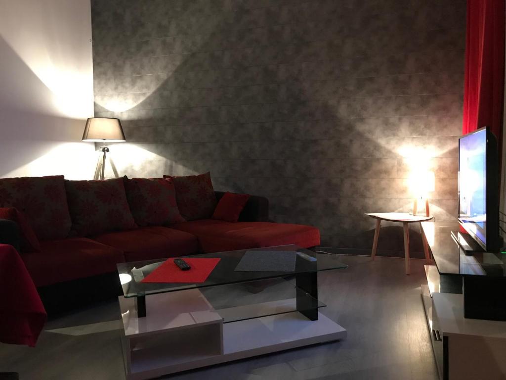 uma sala de estar com um sofá vermelho e uma mesa em Dieppe Appartement em Dieppe